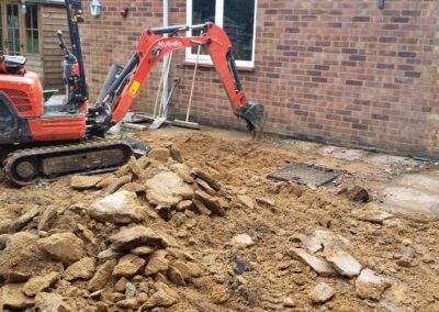 A garden that's being dug out using a mini digger and driver hire service