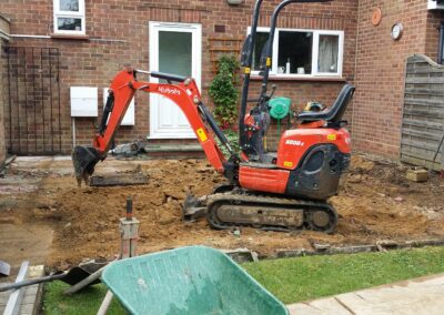 A garden that's being dug out using a mini digger and driver hire service