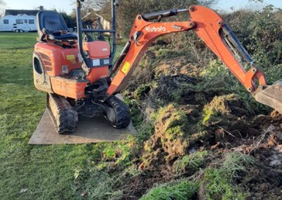 A garden that's being dug out using a mini digger and driver hire service