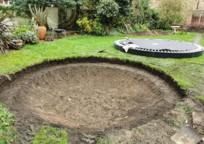 A hole for a sunken trampoline being dug out using a mini digger and driver hire service