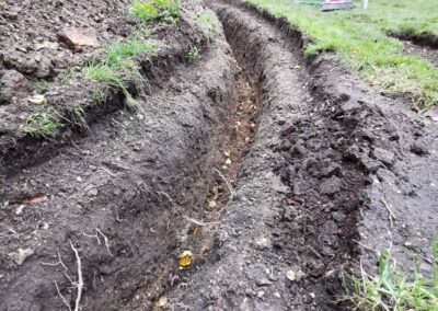 A trench for heat source pump pipework being dug out using a mini digger and driver hire service