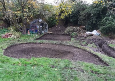 A multi-level pond and patio area being dug out using a mini digger and driver hire service