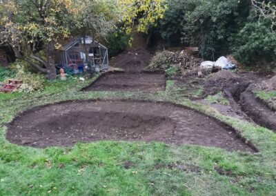 A multi-level pond and patio area being dug out using a mini digger and driver hire service