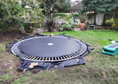 A sunken trampoline being installed after the hole for it being dug out using a mini digger and driver hire service