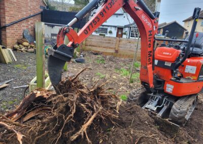 A photo showing the ripper tooth attachment for the mini digger for ripping out roots and tree stumps. Mini digger and driver hire in Hertfordshire, Bedfordshire, and Cambridgeshire - The Mini Digger Guy